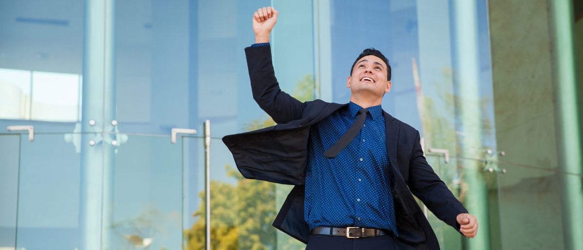 a project manager jumping and throwing his hand on the sky with joy